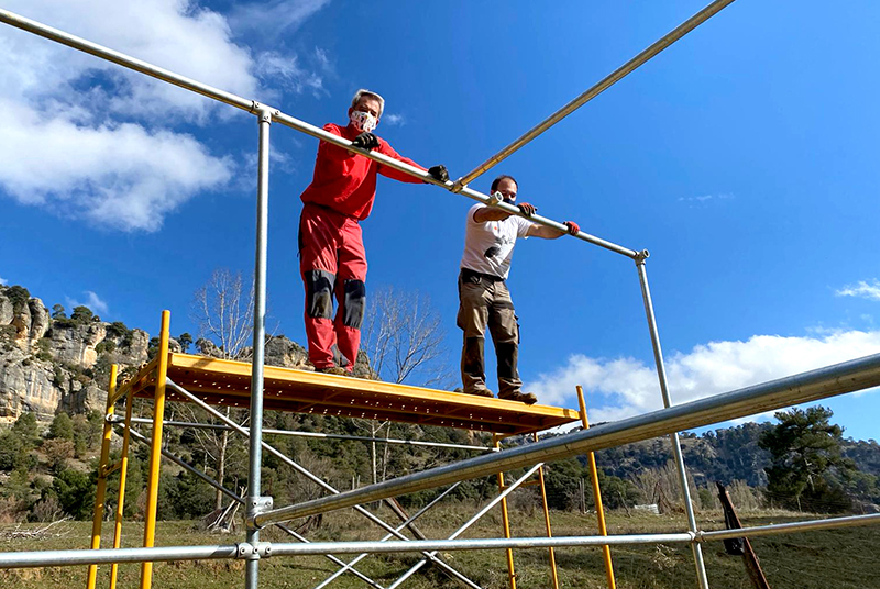 Dos miembros de GREFA levantan la estructura metálica del recinto de aclimatación del milano real en Cazorla. Foto: Junta de Andalucía.