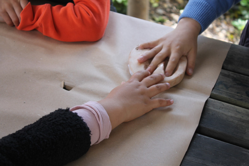 Manos de niños sobre la réplica de una huella de un animal en un taller de GREFA
