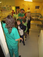 7. Varias familias visitan la sala de necropsias, guiadas por una veterinaria.