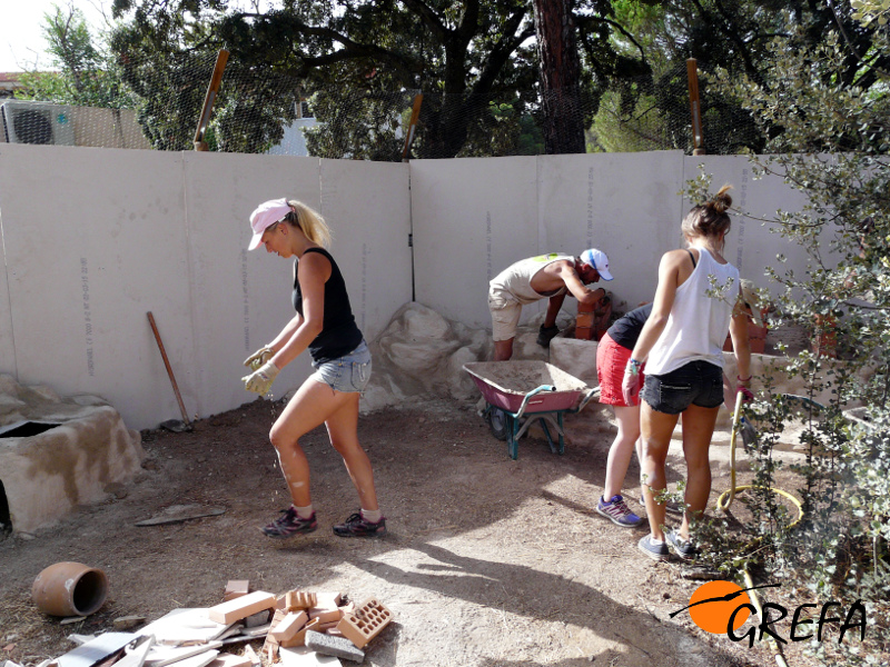 Varios voluntarios internacionales trabajan en el acondicionamiento del recinto destinado a las cigüeñas negras, en el centro de GREFA.