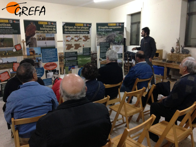 Carlos Cuéllar, responsable en GREFA del proyecto de control biológico de topillos, explica a unos vecinos de Caleruega (Burgos) el contenido de la exposición.