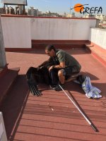 Un miembro de GREFA rescata a un buitre negro en la azotea de un edificio.