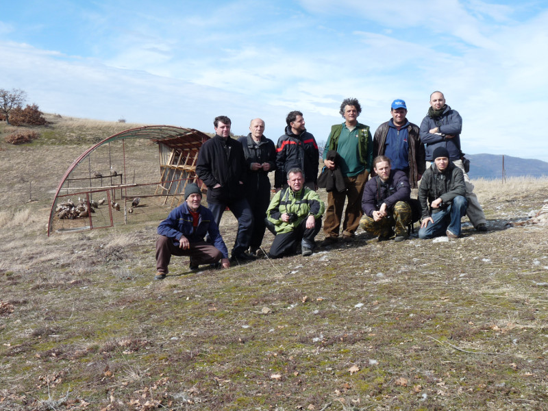 Miembros de Green Balcans y GREFA posan con la jaula de aclimatación en Bulgaria de fondo