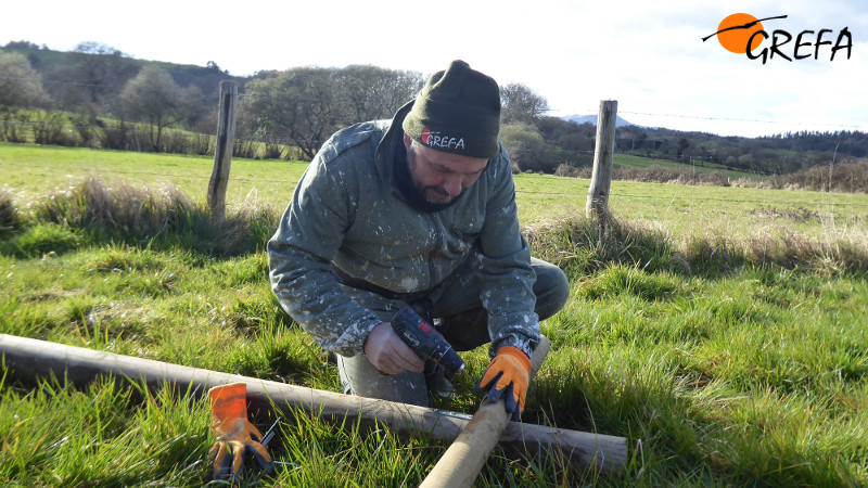 Un trabajador de GREFA prepara un poste para una caja nido de rapaces depredadoras de micromamíferos en Sariego (Asturias).