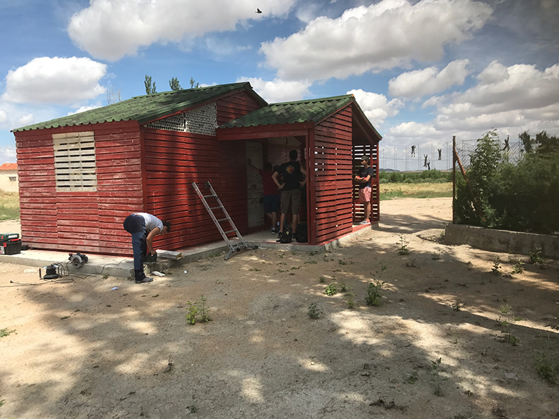 Voluntarios internacionales rematan una construcción realizada con palés en el campo de trabajo de Villalar.