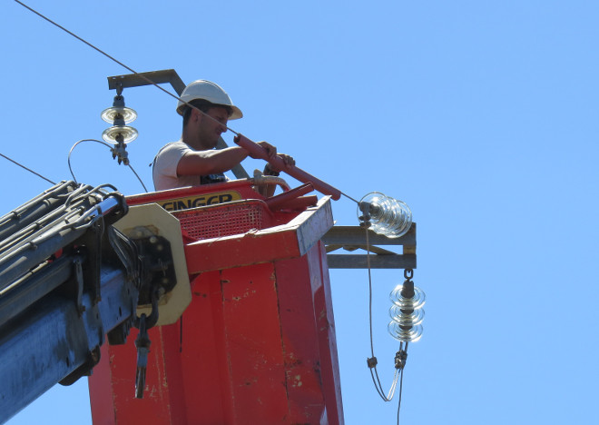 Un operario aísla el cable de un tendido eléctrico peligroso para las aves.