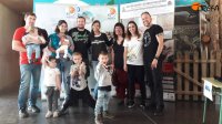 Varias familias posan junto a la cartelería del proyecto AQUILA a-LIFE durante el Día del Águila celebrado en GREFA.