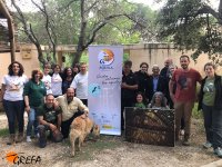 Trabajadores, voluntarios y amigos de GREFA posan en el Día del Águila junto a un cartel de nuestro proyecto.