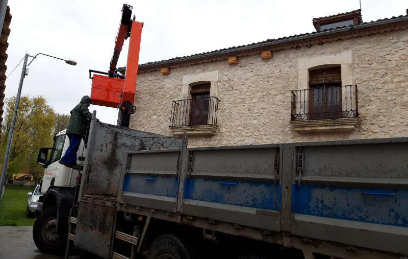 Una grua facilita la instalación de varias cajas nido para aves insectívoras en una casa de Vegafría (Segovia).