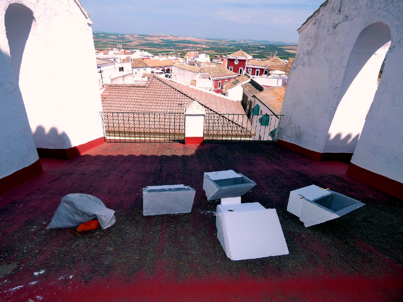 En primer plano, varias cajas nidos para cernícalo primilla y, al fondo, panorámica de Fernán Núñez y alrededores, donde predomina la campiña cerealista.