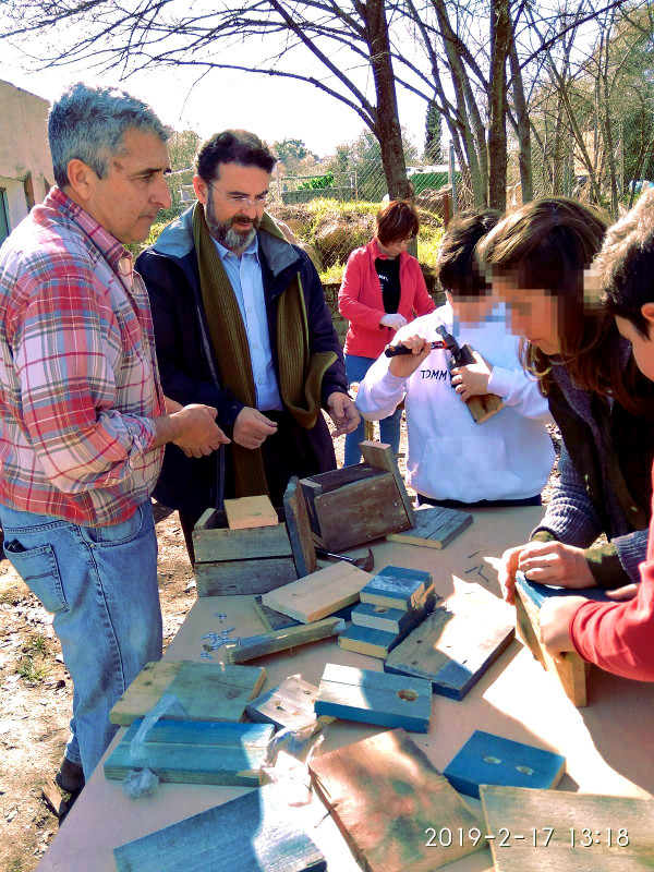 Nuestro compañero de GREFA Andalucía, Luis Jiménez, ayuda a construir una caja nido a varios asistentes al taller.