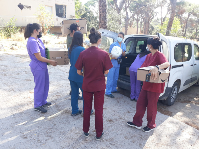 Varias voluntarias y un voluntario del Hospital de Fauna Salvaje de GREFA descargan parte del material donado por "Huellas".