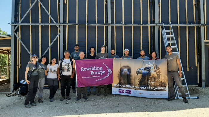 Representantes de las ONG que colaboran en el proyecto, junto al jaulón de aclimatación donde han sido introducidos los buitres negros.