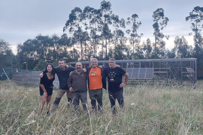 El grupo de visitantes del Proyecto Pigargo, junto con el equipo del proyecto, delante de la instalación de pre-suelta, en Pimiango (Asturias). Foto: Luís Jiménez.