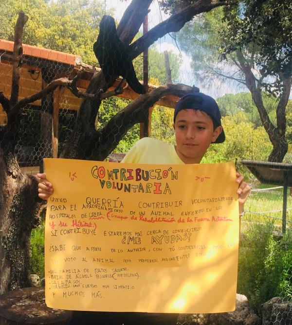 Marcos Bueno, un chaval que en 2018 con 11 años promovió una campaña de recaudación entre sus vecinos de Tres Cantos (Madrid) para poder apadrinar a "Cornelius", posa junto a su ahijado y con un cartel en el que explicaba su iniciativa.