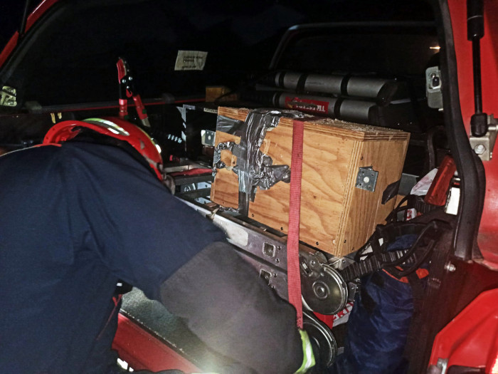 Los bomberos colocan la caja nido con las abejas en el vehículo que las trasladará.