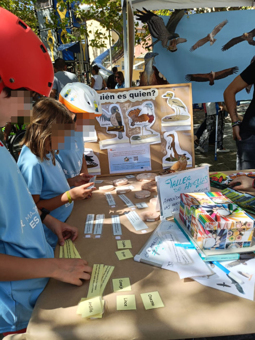 Varios niños participan en un taller de huellas organizado por GREFA en la feria.