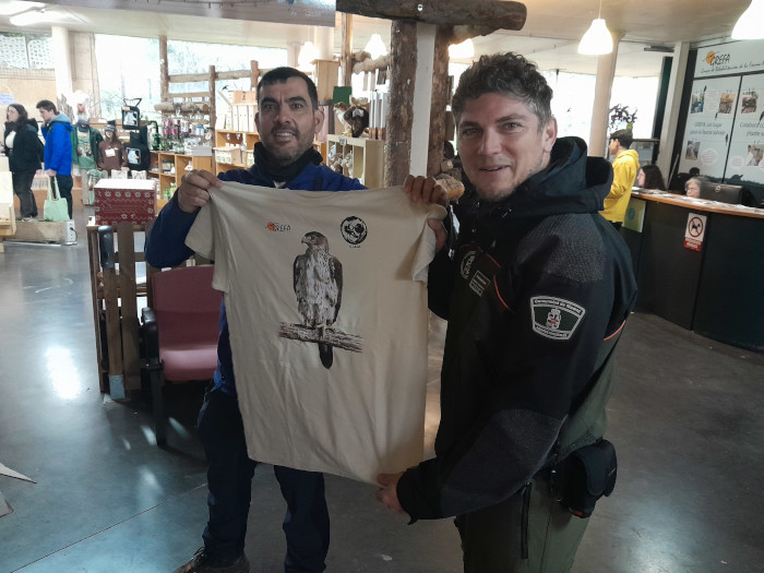 Acto de entrega de camisetas con logo de GREFA y símbolo de propio GIAM a un miembro de este equipo.