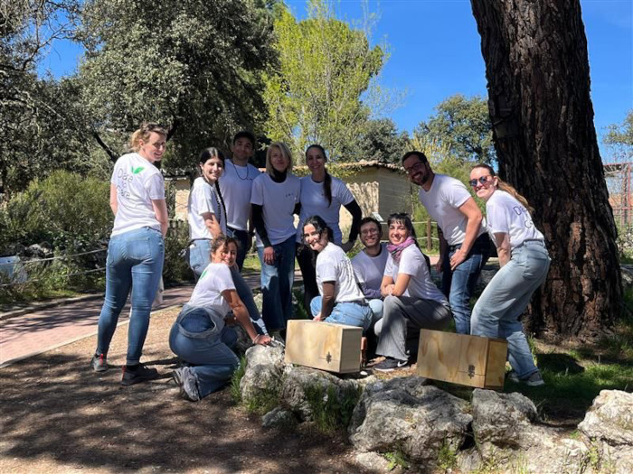 Empleados de Kenes Group posan junta a las cajas nido para pequeñas rapaces que han montando en GREFA. 